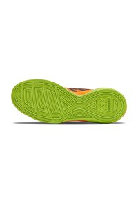 Schoenzool met een levendige groene rubberen laag en gestructureerde patronen, contrasterend met een zwart en oranje bovenwerk met merkdetails.