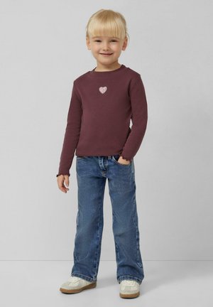 Bordeaux lange mouwen shirt met een sprankelende hartapplicatie, gecombineerd met lichtblauwe spijkerbroek en witte sneakers. Casual pasvorm met gerimpelde manchetten.