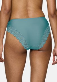 Szmaragdowe majtki wysokie z gładkiego materiału z falbanką koronkową po bokach, z misternymi wzorami w zawirowania.