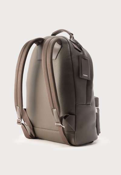 Σκούρο γκρι υφασμάτινο δερμάτινο σακίδιο με επενδεδυμένους ιμάντες, πάνω λαβή, πλαϊνή τσέπη και μια μικρή ορθογώνια ετικέτα με την ένδειξη "SANDRO".