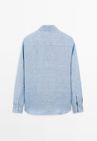Light blue long-sleeve shirt made of textured fabric. Features a pointed collar, button cuffs, and a curved hem. Back view shows reinforced seams.