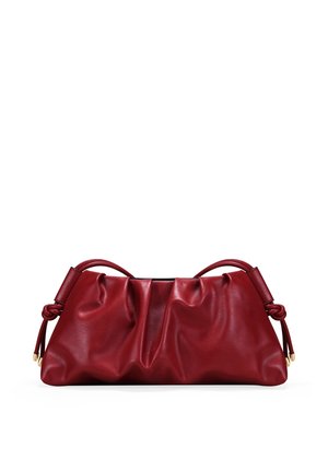 Bolso de mano de cuero rojo suave con detalles fruncidos, asas cortas anudadas y puntas en tono dorado sobre fondo blanco.