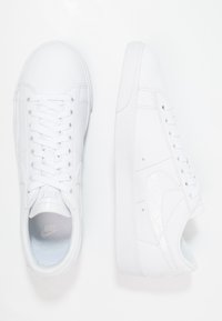 Zapatillas Nike blancas con parte superior de cuero suave, puntera redonda y diseño de cordones; cuentan con un logotipo sutil y acentos texturizados.