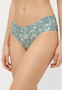 Zöld katonai mintás női bikini alsó, sima anyagból készült, puha tapintással és alacsony derékkal.