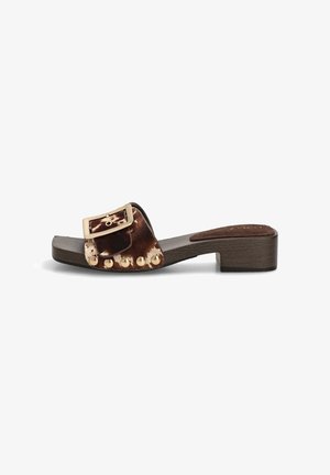 Sandalia deslizable marrón de tacón bajo con una amplia correa de piel manchada, hebilla grande dorada y tachuelas doradas a lo largo del lado de la correa.