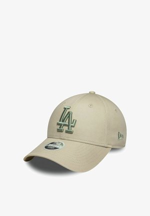 Casquette de baseball beige avec logo "LA" vert brodé sur le devant et petit logo sur le côté, visière courbée, et autocollant sur le dessus de la visière.