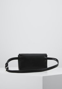 Czarna skórzana torebka crossbody o prostokątnym kształcie, teksturowanym wykończeniu, regulowanym pasku i małym logo. Prosty i funkcjonalny design.