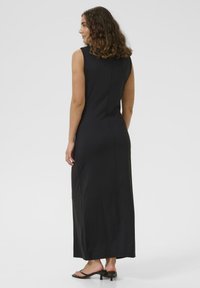 Rochie maxi fără mâneci, de culoare neagră, realizată dintr-o țesătură fină, având o siluetă aderentă, cu un tiv drept și fără modele sau embellishments vizibile.