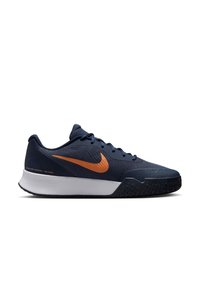 Chaussure de sport Nike avec une tige en mesh bleu marine, logo swoosh orange, semelle intermédiaire blanche et semelle extérieure en caoutchouc noir texturé.