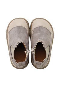 Zapatos gris de ante tipo slip-on con acentos elásticos y punta redondeada. Cuenta con una parte superior de cuero beige y una suela de goma texturizada.