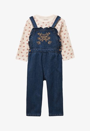 Chemise longue crème à manches longues avec de petites fleurs rouges, associée à une salopette en denim bleu ornée de broderies florales sur la poitrine et de bretelles à volants.
