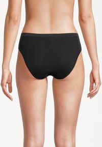 Czarne figi hipsterskie z nylonu o bezszwowej konstrukcji, elastycznym pasie i gładkiej fakturze. Posiadają pełne pokrycie tylnej części i minimalne detale przeszyć.