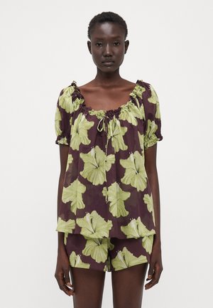 Conjunto de blusa de mangas curtas e calções em roxo escuro com estampa floral verde grande. Tecido leve, decote elástico e corte solto.