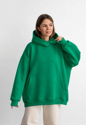 Overmaat groene hoodie van zacht materiaal met een grote voorkauw, een hoge kraag en een trekkoord in de capuchon.