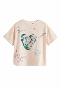 Cămașă T-shirt din bumbac de culoare roz deschis, cu un croi oversized. Are un design cu inimă verde, decorat cu imprimeu floral și text scris de mână în diverse culori.