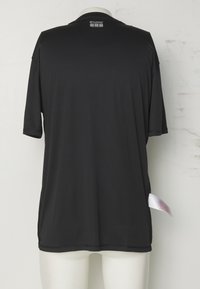 Must lühikeste varrukatega spordisärk, mis on eksponeeritud mannequin'i tagaküljelt, küljes "hummel" logo ja hooldusmärk peal nähtaval.