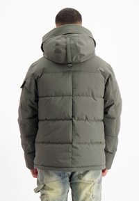 Gevulde groene parka met een grote capuchon, voorzien van horizontaal gestikte secties, een verstelbare riem en een logo bij de nek.
