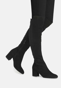 Schwarze Overknee-Stiefel aus Kunstwildleder mit Blockabsatz, spitz zulaufender Zehenpartie und einem seitlichen Reißverschluss für einfaches An- und Ausziehen.