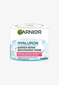 Przezroczysty plastikowy słoik z białym kremem i niebieskimi akcentami. Etykieta zawiera wyraźne napisy "Hyaluron" i "Barrier Repair". Odpowiedni do skóry wrażliwej.