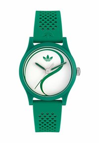 Orologio in silicone verde con quadrante rotondo bianco, caratterizzato da un design curvo verde, lancette in argento e un cinturino verde testurizzato con perforazioni.
