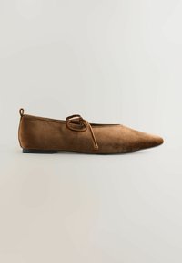 Brune ruskinds flade sko med spidse tå, med en bundet detalje foran og en flad sort sål. Glat tekstur med et rent design.