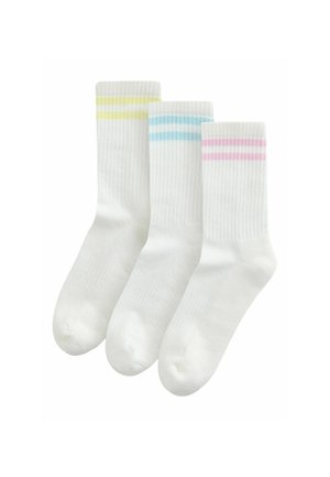 White crew socks with ribbed texture, featuring pastel stripes in yellow, blue, and pink on top. Three pairs displayed together.