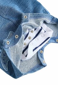 Denim body s dlhým rukávom s modrými prúžkami a patentkami, odhaľujúcou bielu a námornícku pruhovanú vnútornú vrstvu. Mäkká bavlnená tkanina.