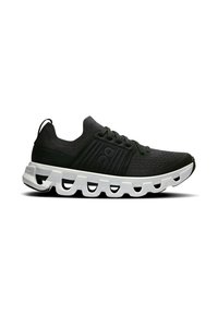 Baskets de sport noires avec une tige texturée, dotées d'une semelle blanche rembourrée et d'éléments de design distinctifs en forme de nuage.