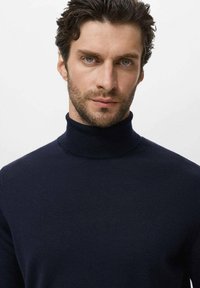 Suéter de cuello alto de color azul marino, fabricado en un tejido liso y de punto fino; diseño ajustado con un cuello alto; estilo minimalista sin patrones ni acentos visibles.