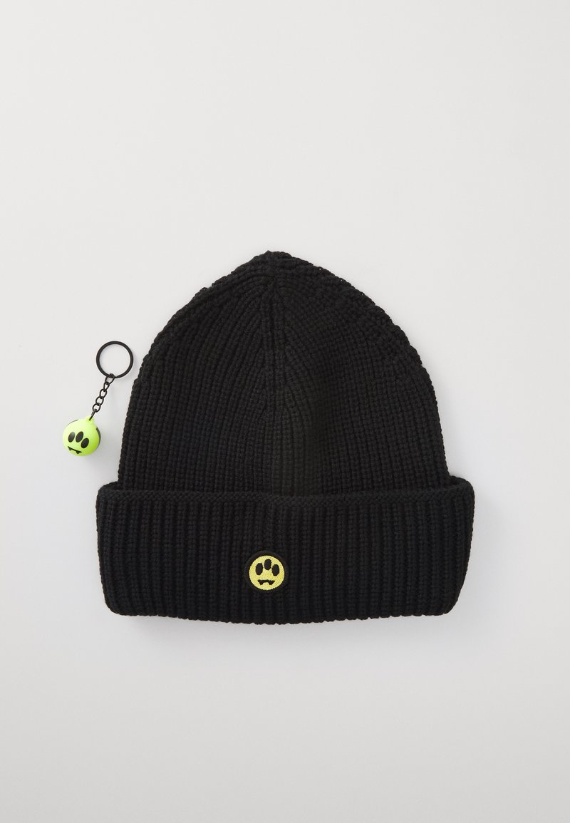 Gorro de punto negro con un puño doblado, que presenta un logo de cara sonriente amarilla y un llavero de bola verde neón desprendible.
