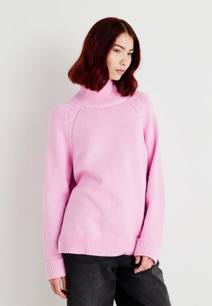 Roze gebreide trui met een hoge kraag, geribbelde cuffs en zoom. Heeft een losse pasvorm en subtiele textuur. Gekocht met grijze broek.