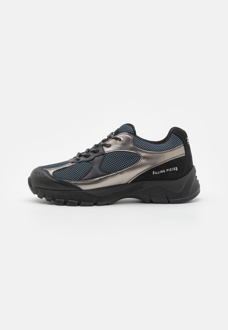 Baskets noires et gris métallisé avec panneaux en mesh, semelle épaisse, fermeture à lacets et marquage "Filling Pieces" sur le côté et au talon.
