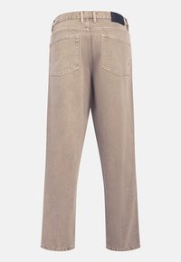 Pantalones de mezclilla beige con diseño de cinco bolsillos, cintura de altura media y corte recto. Presenta un parche trasero de color azul oscuro. Textura suave.