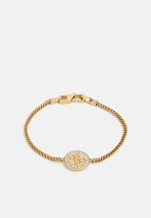 Goudkleurige stalen armband met een gedraaide schakeldesign, met een ronde bedel versierd met een logo en een ring van heldere kristallen.