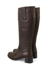 Bottes en cuir marron jusqu'au genou avec une finition lisse, des talons carrés et des détails cousus sur les côtés. Présentent une boucle en haut pour le style.