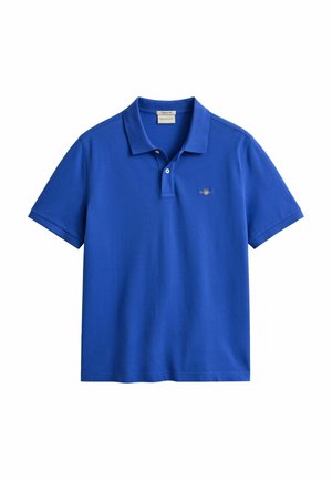 Sininen lyhythihainen poolopaita, jossa on kaksi valkoista nappia ja pieni kirjailtu logo vasemmassa rinnassa.