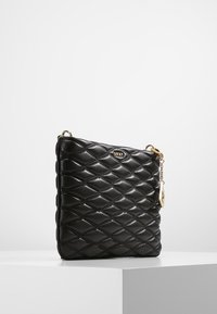 Borsa a tracolla in pelle nera con motivo trapuntato, accessori in tonalità oro e charm removibile. Forma quadrata con una texture liscia e lucida.