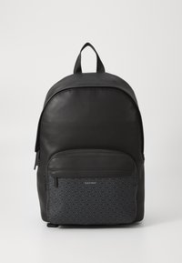 Zaino nero con superficie in similpelle liscia e tasca frontale in tessuto con motivo che presenta il logo Calvin Klein. Due spallacci e maniglia superiore.