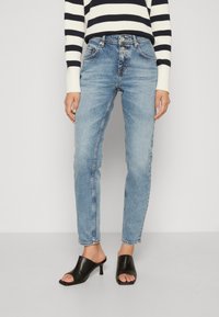 Light blue denim jeans with a high waist and straight leg, featuring a faded finish and five-pocket design. Worn with black open-toe heels.