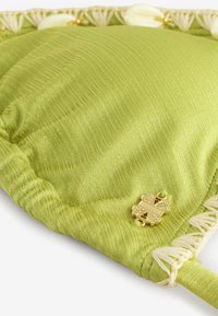 Perna verde texturată cu detaliu metalic auriu și margine decorativă crem. Prezintă o suprafață netedă, cu dungi și margini împodobite.