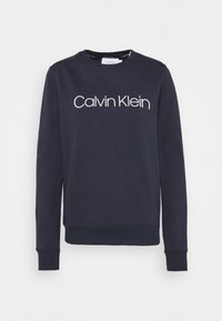 Felpa a maniche lunghe blu navy con colletto rotondo e logo bianco "Calvin Klein" centrato sul petto.