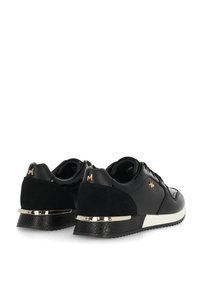 Svarta sneakers med texturerad läder- och mockamaterial, med ett guldaccentband och logodetalj på hälen. Sportig snörningsdesign.