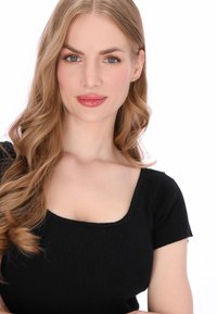 Fekete, bordázott anyagú, rövid ujjú felső négyzet alakú nyakkivágással. A modell hosszú, hullámos hajú és természetes sminket visel. Fehér háttér.