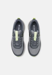 Harmaat verkkourheilukengät vihreillä yksityiskohdilla, joissa on pehmustettu kaulus, nauhat ja kuvioidut pohjat hyvään pidon takaamiseksi. Logot lisätty kielen kohdalle.