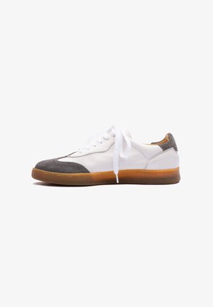 Leather sneakers with a white body, gray suede toe and heel accents, white laces, and a rubber gum sole. Features stitching detail on the upper.