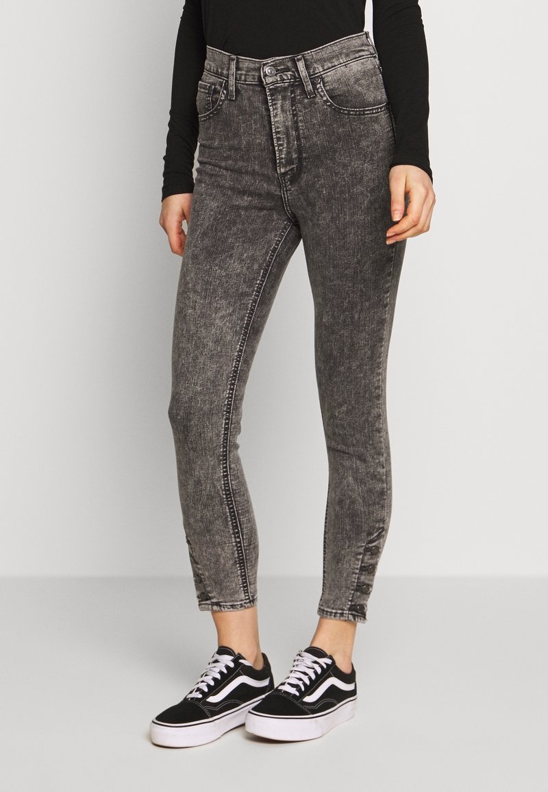 Höga svarta denimjeans med en blekt textur, med dragkedja och knappstängning samt sydda sidodetaljer. Matchas med svarta sneakers.