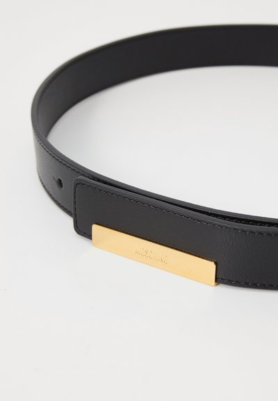 Cinturón de cuero negro con textura suave, placa rectangular de metal dorado con el nombre de la marca grabado y dos agujeros de ajuste.