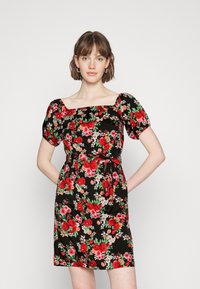 Vestido preto com padrão floral, apresentando rosas vermelhas e brancas, mangas bufantes, decote quadrado e detalhe de cinta. Tecido suave com forma ajustada.