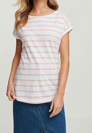 Vrouw draagt een wit T-shirt met lichtroze horizontale strepen en omgeslagen mouwen, gecombineerd met een blauwe spijkerrok.