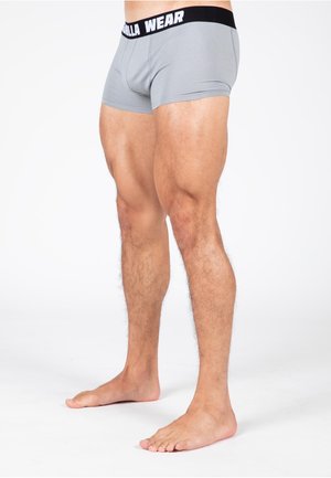 Grijze boxershorts van katoen met een zwarte tailleband met de tekst "GORILLA WEAR." Gladde textuur, aansluitend ontwerp, lengte tot halverwege de dij.